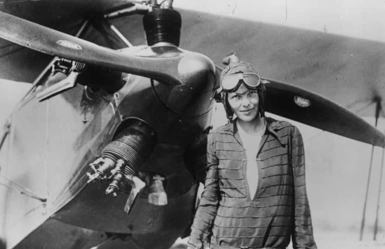 Amelia Earhart stands next to her Kinner Airster - What Happened to Amelia Earhart